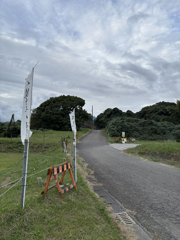 入口への道。右手にPの看板と駐車場が見える
