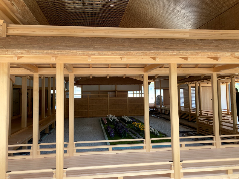 博物館2階の朝倉館原寸再現エリア内部。柱・梁・縁側が原寸大で再現され、中庭に花が植えられている。