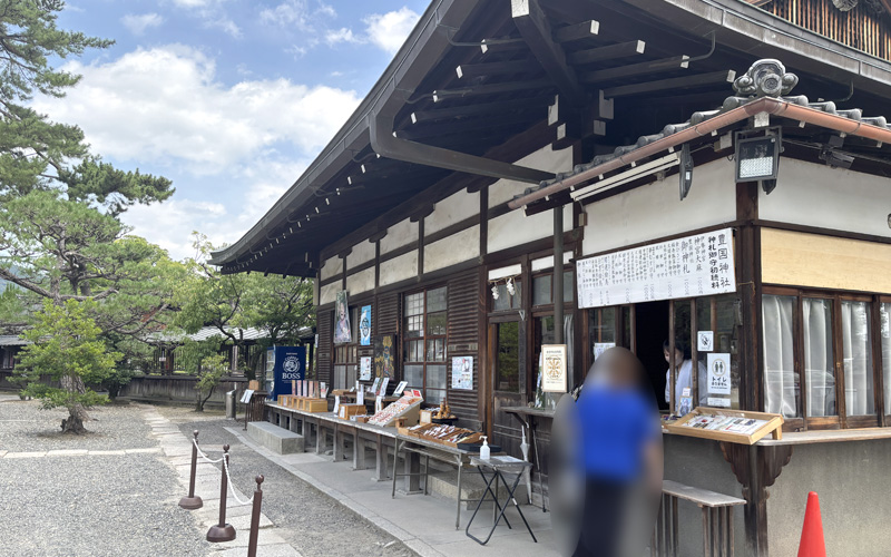 豊国神社(京都)の社務所。授与品が並び、参拝者が受付に立っている