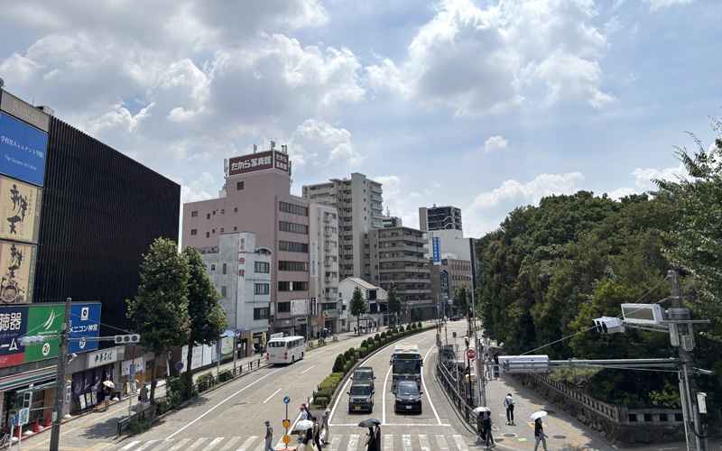歩道橋から見た熱田神宮周辺の街並み。商店やビルが立ち並ぶ通り。